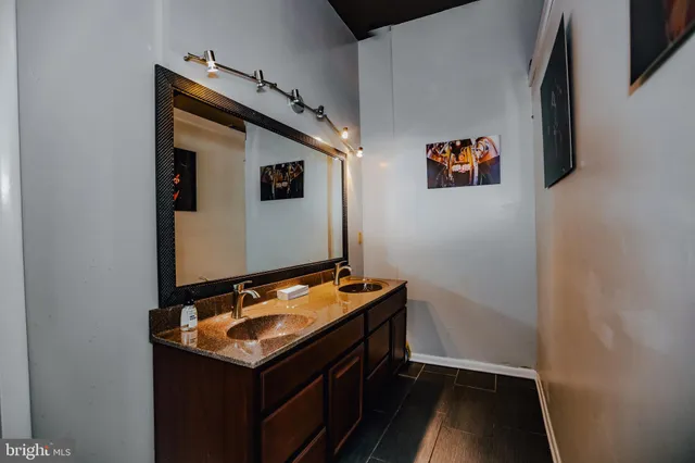 a large open kitchen with stainless steel appliances kitchen island granite countertop a refrigerator a stove a sink and a dining table with wooden floor