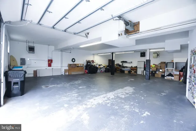 a kitchen with wooden floors stainless steel appliances a sink and a large window
