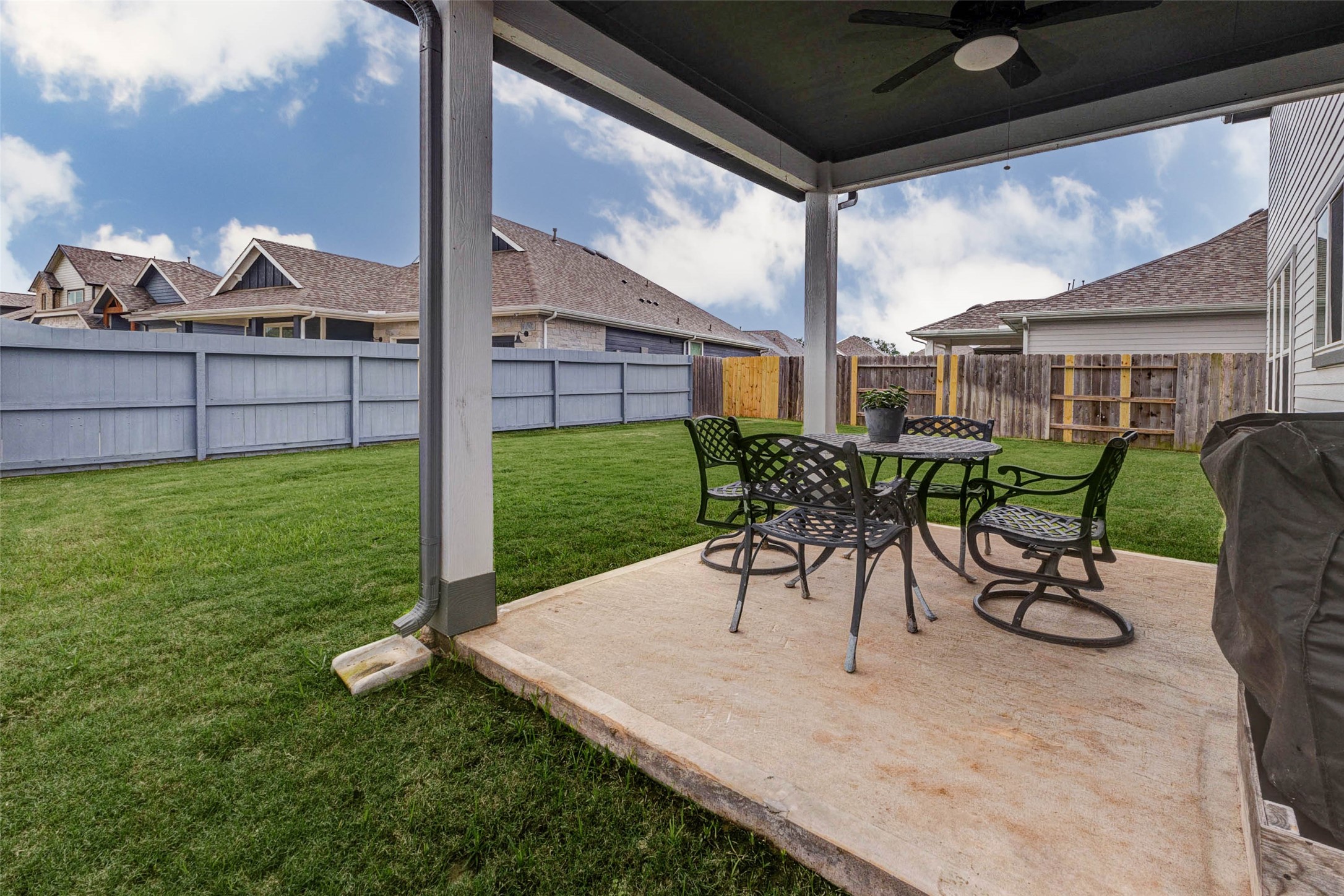 32418 Fly Fish Way Fulshear, TX 77441 - Photo 37 of 40 This closer look at the covered patio highlights the generous concrete slab with ample room for a full outdoor dining set and grill, all tucked beneath the shade of the covered overhang with a ceiling fan overhead.