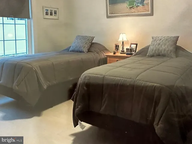 a bedroom with two beds and a painting on the wall