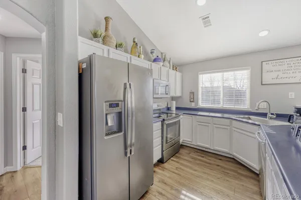 a kitchen with stainless steel appliances a refrigerator sink and cabinets