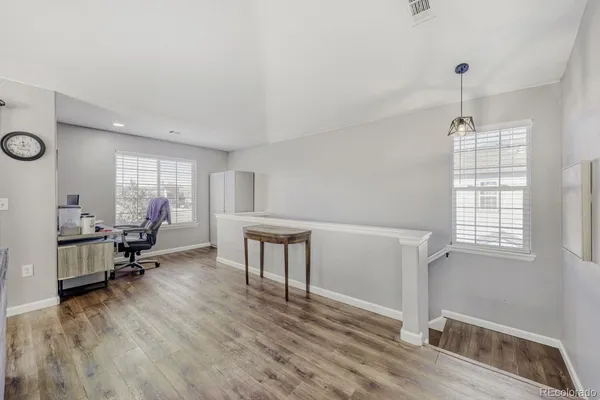 a living room with furniture and a wooden floor