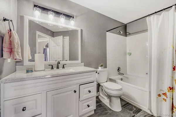 a bathroom with a granite countertop sink a toilet and a mirror