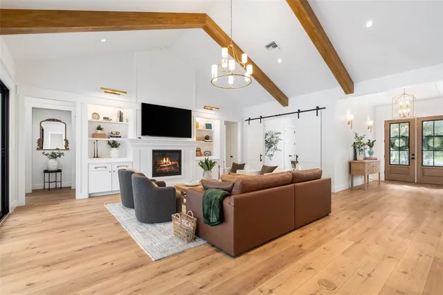 a living room with furniture kitchen view and a wooden floor