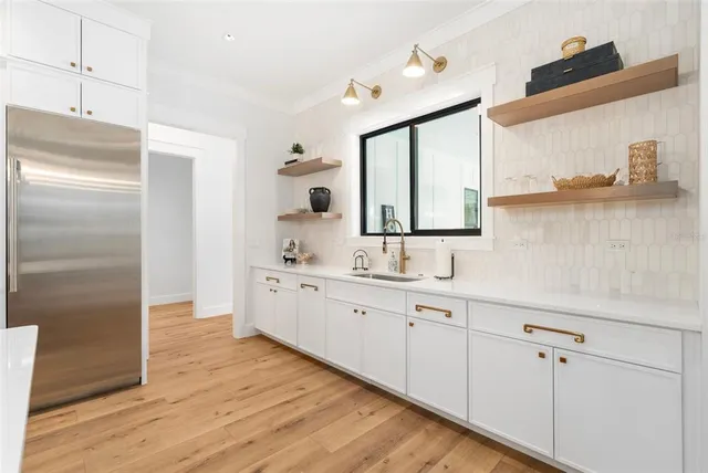 a hallway with white cabinets and wooden floor