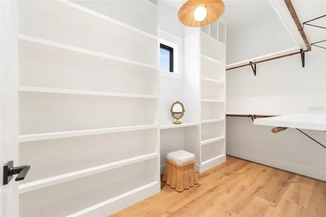 a spacious bedroom with a large bed and a chandelier