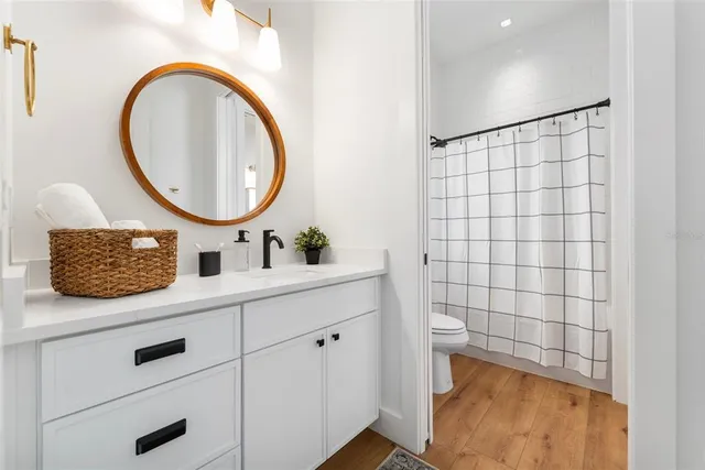 a bathroom with a granite countertop sink a toilet and shower