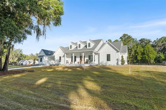 a view of a large house with a big yard and palm trees