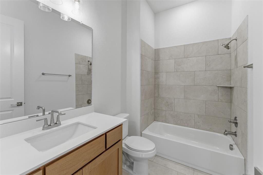 815 Vly Rdg Road Van Alstyne, TX 75495 - Photo 9 of 29 Full bathroom featuring a single vanity with wood cabinetry, a white countertop, and an undermount sink