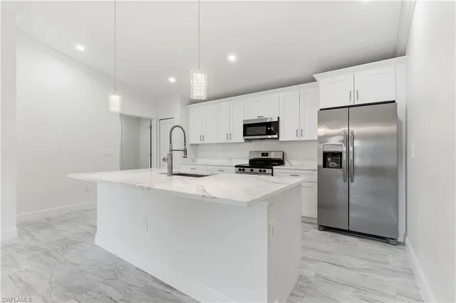 a kitchen with stainless steel appliances a refrigerator sink and microwave