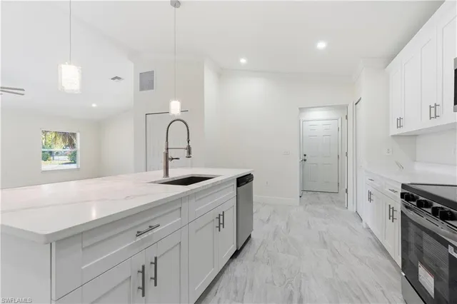 a kitchen with a sink a stove and cabinets