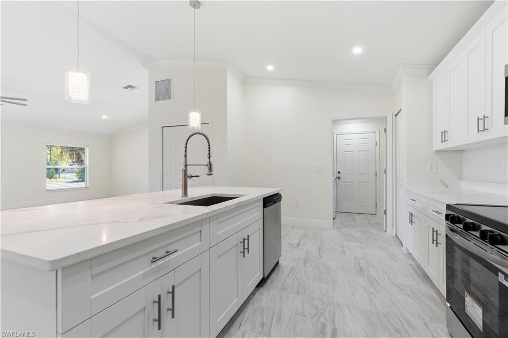 2141 Davis Street Fort Myers, FL 33916 - Photo 13 of 50 a kitchen with a sink a stove and cabinets