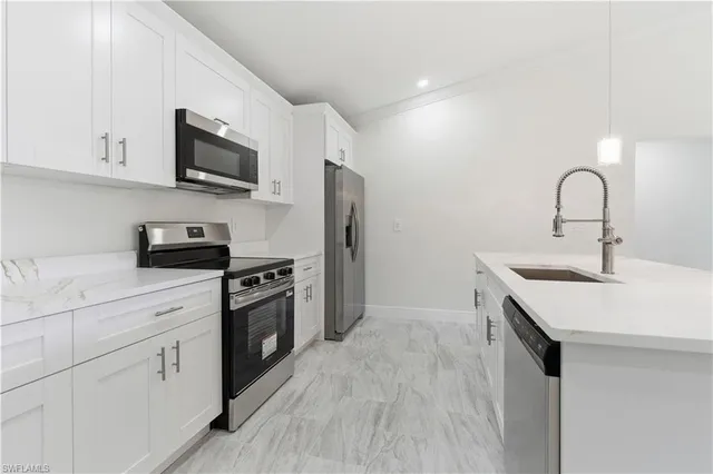 a kitchen with white cabinets stainless steel appliances and sink