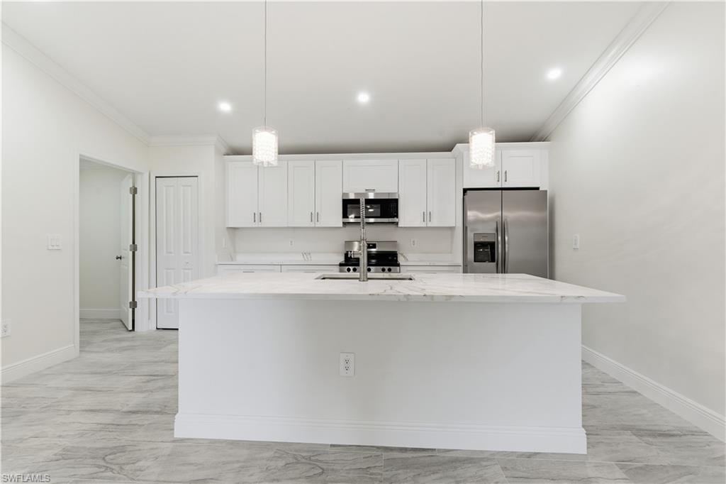 2141 Davis Street Fort Myers, FL 33916 - Photo 17 of 50 a large kitchen with stainless steel appliances a refrigerator a stove a sink a microwave and white cabinets