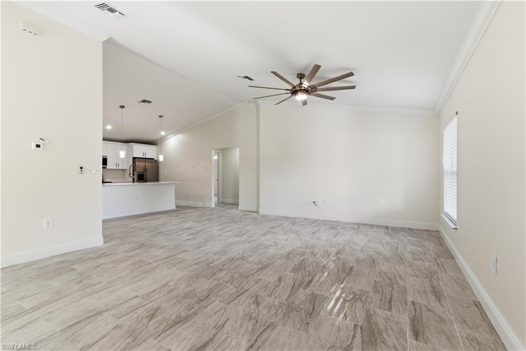 2141 Davis Street Fort Myers, FL 33916 - Photo 7 of 50 a view of a big room with wooden floor a ceiling fan and windows