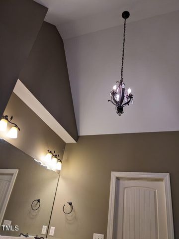 a view of a room with a chandelier fan and wooden floor