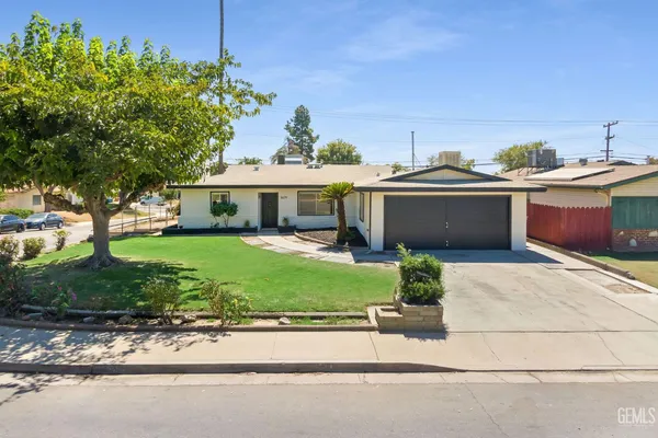a front view of a house with a garden and yard