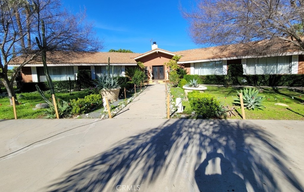8805 Dufferin Avenue Riverside, CA 92504 - Photo 2 of 23 a front view of a house with a yard and potted plants