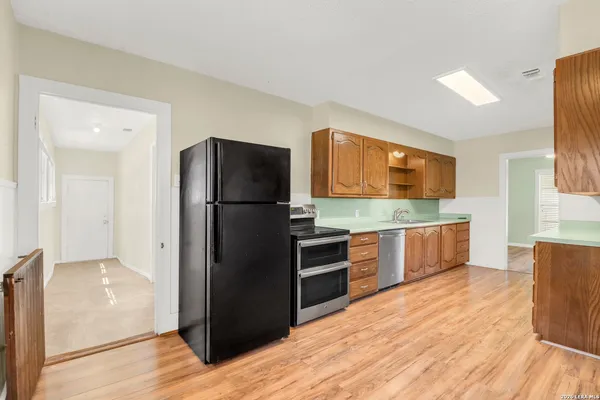 a kitchen with stainless steel appliances a refrigerator and wooden cabinets