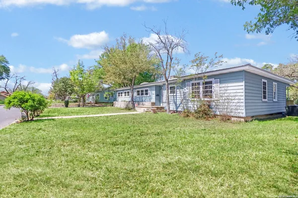 a view of a house with backyard and a garden