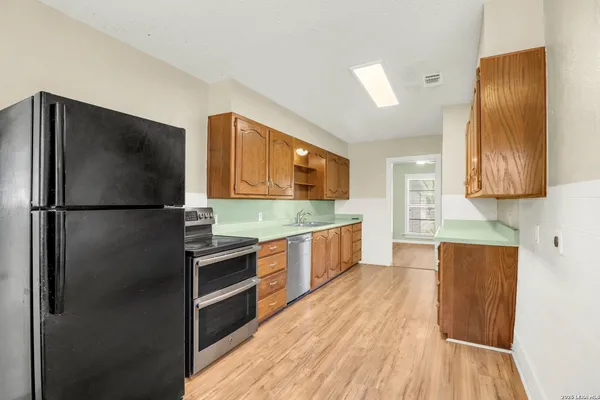 a kitchen with stainless steel appliances a refrigerator and a stove top oven
