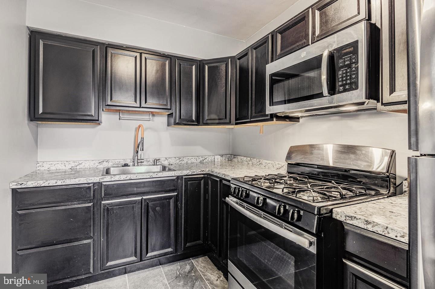 1106 Meridene Drive Baltimore, MD 21239 - Photo 2 of 9 a kitchen with granite countertop a stove and a sink