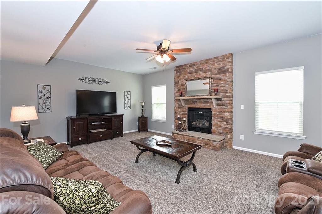 3006 Fallondale Road Waxhaw, NC 28173 - Photo 14 of 48 a living room with furniture a flat screen tv and a fireplace