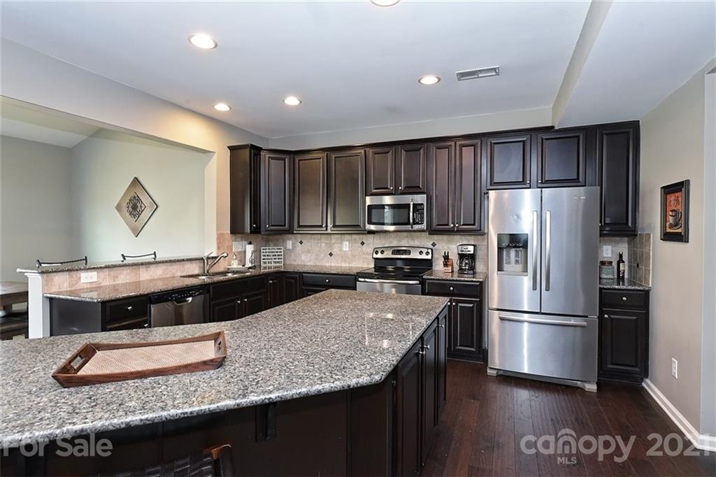 3006 Fallondale Road Waxhaw, NC 28173 - Photo 20 of 48 a kitchen with kitchen island granite countertop stainless steel appliances and wooden cabinets