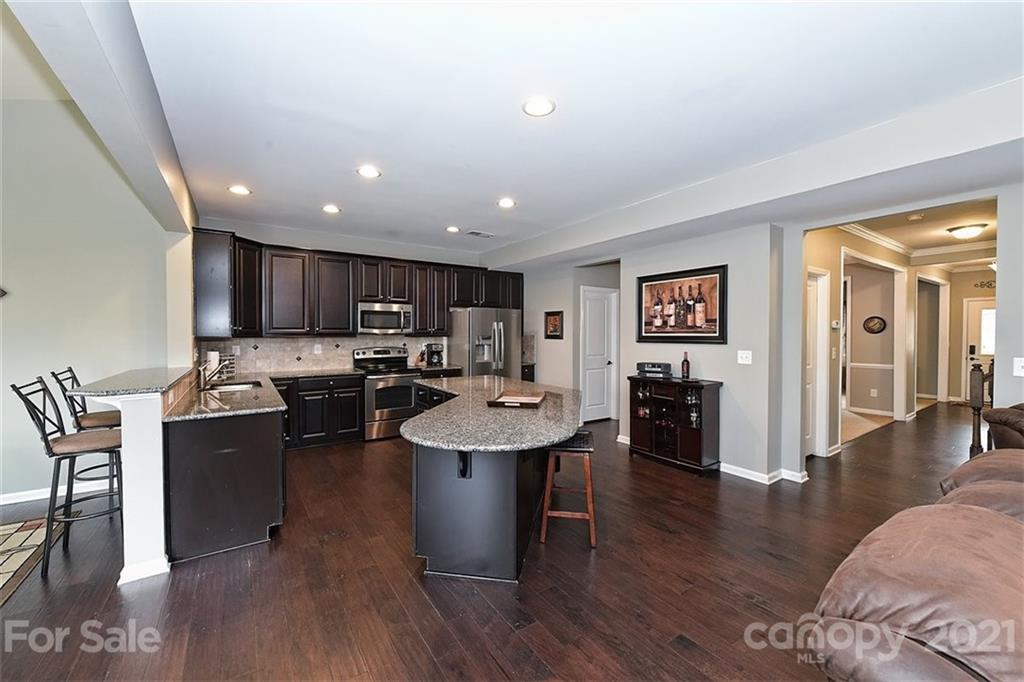 3006 Fallondale Road Waxhaw, NC 28173 - Photo 21 of 48 a living room with stainless steel appliances kitchen island granite countertop furniture wooden floor and a view of kitchen
