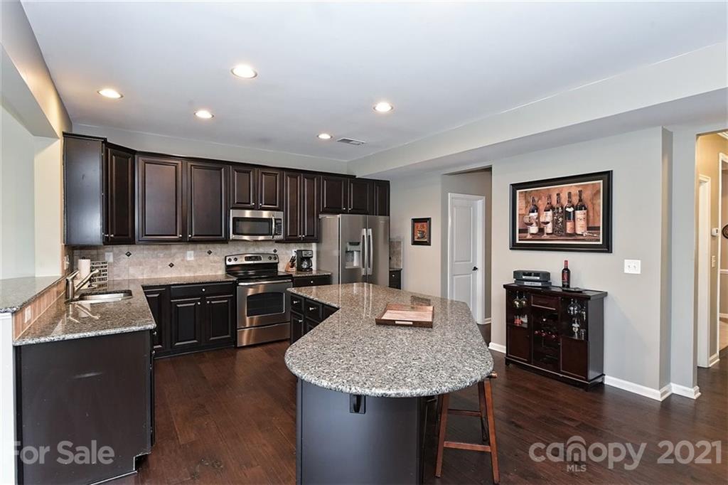 3006 Fallondale Road Waxhaw, NC 28173 - Photo 22 of 48 a kitchen with stainless steel appliances granite countertop a sink stove and refrigerator