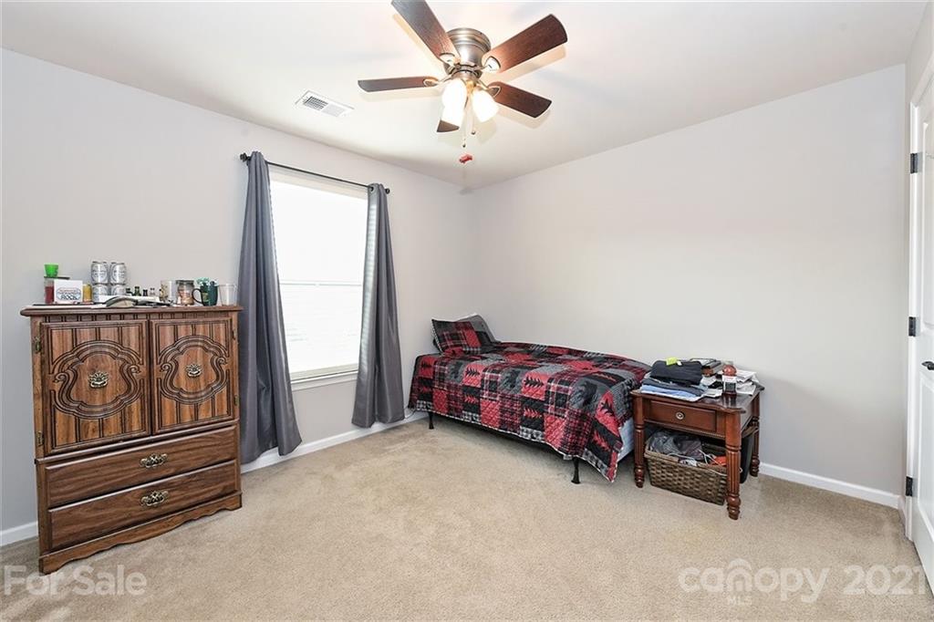 3006 Fallondale Road Waxhaw, NC 28173 - Photo 28 of 48 a bedroom with bed and a chandelier