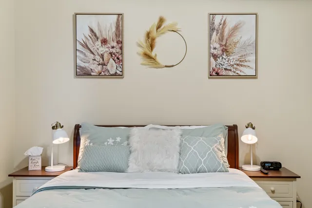 a bedroom with a bed and painting on the wall