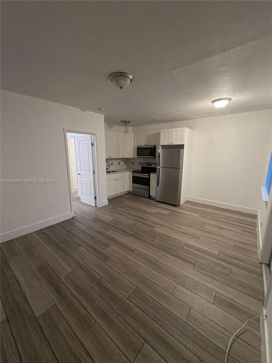1145 Northwest 3rd Street, Unit 3 Miami, FL 33128 - Photo 3 of 8 a room with stainless steel appliances wooden floor and view living room