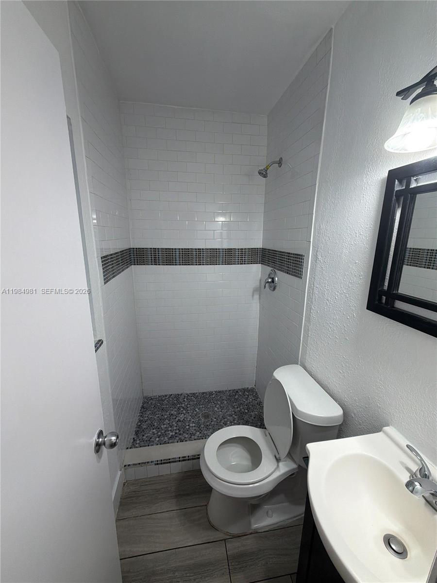 1145 Northwest 3rd Street, Unit 3 Miami, FL 33128 - Photo 6 of 8 a bathroom with a sink a toilet and shower
