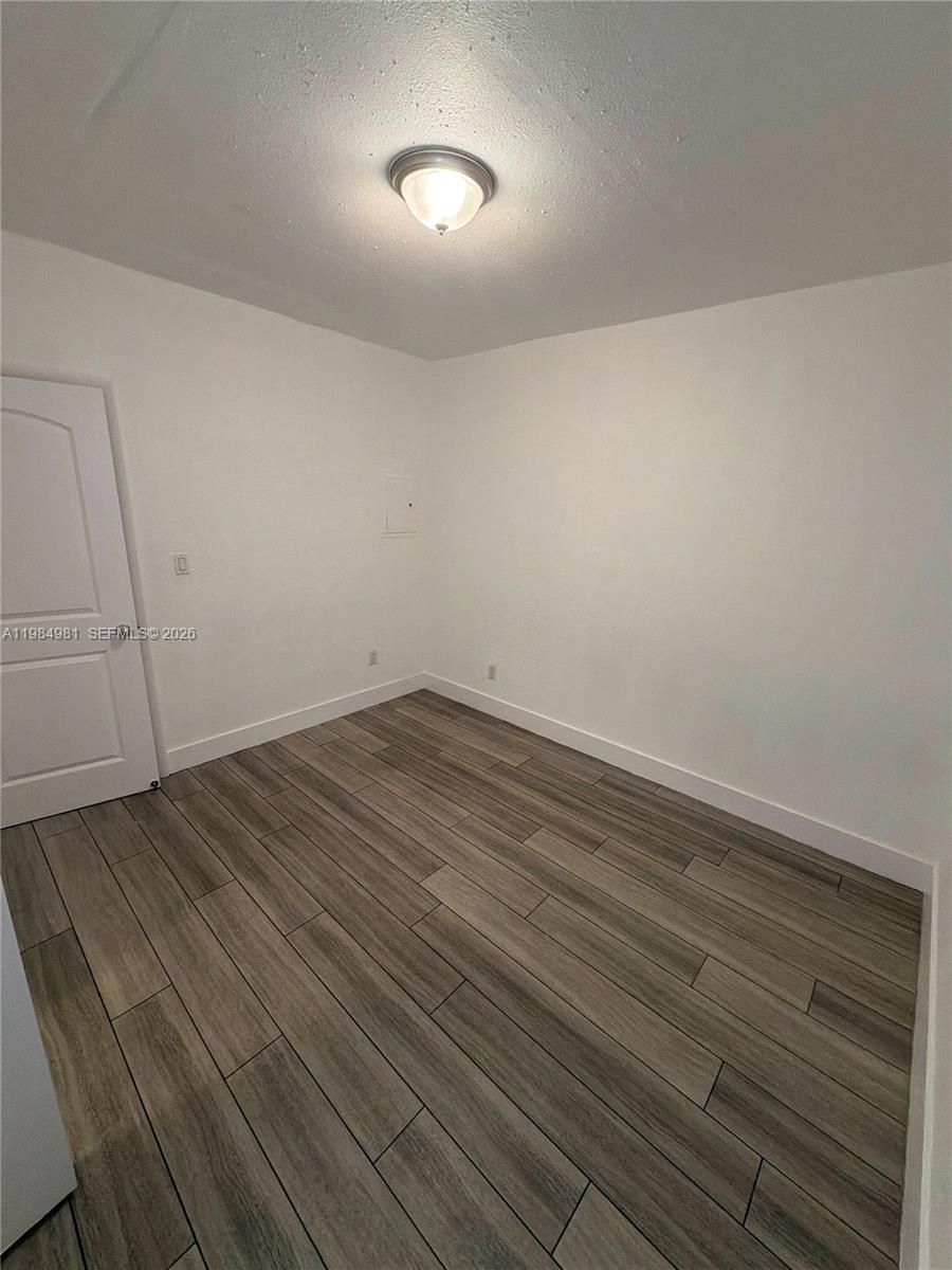 1145 Northwest 3rd Street, Unit 3 Miami, FL 33128 - Photo 8 of 8 a view of room with wooden floor and cabinet