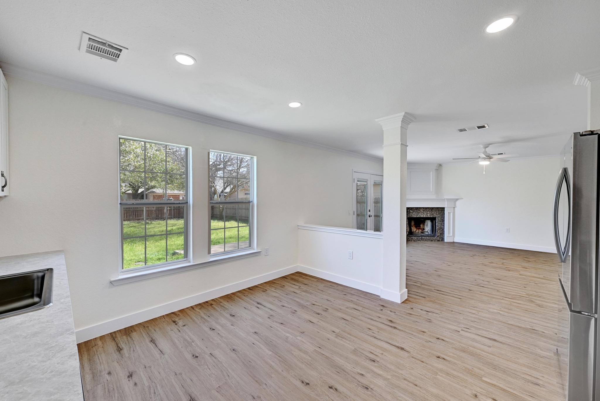7413 L Marble Ridge Drive Austin, TX 78747 - Photo 11 of 30 Open-concept area featuring wood-finish flooring, recessed lighting, and a partial wall with decorative column