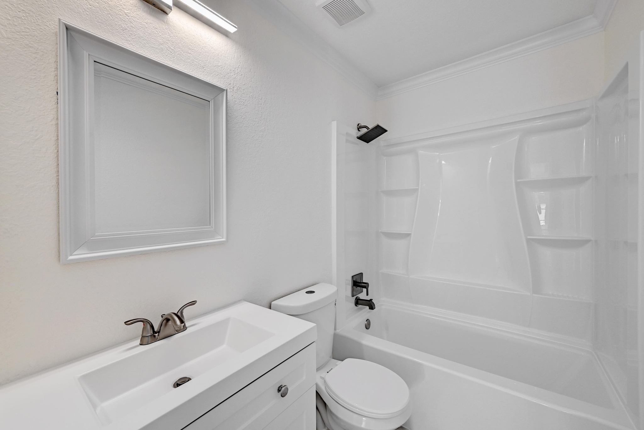 7413 L Marble Ridge Drive Austin, TX 78747 - Photo 21 of 30 Bathroom featuring a white vanity with an integrated sink, brushed nickel faucet, and a framed mirror with overhead lighting