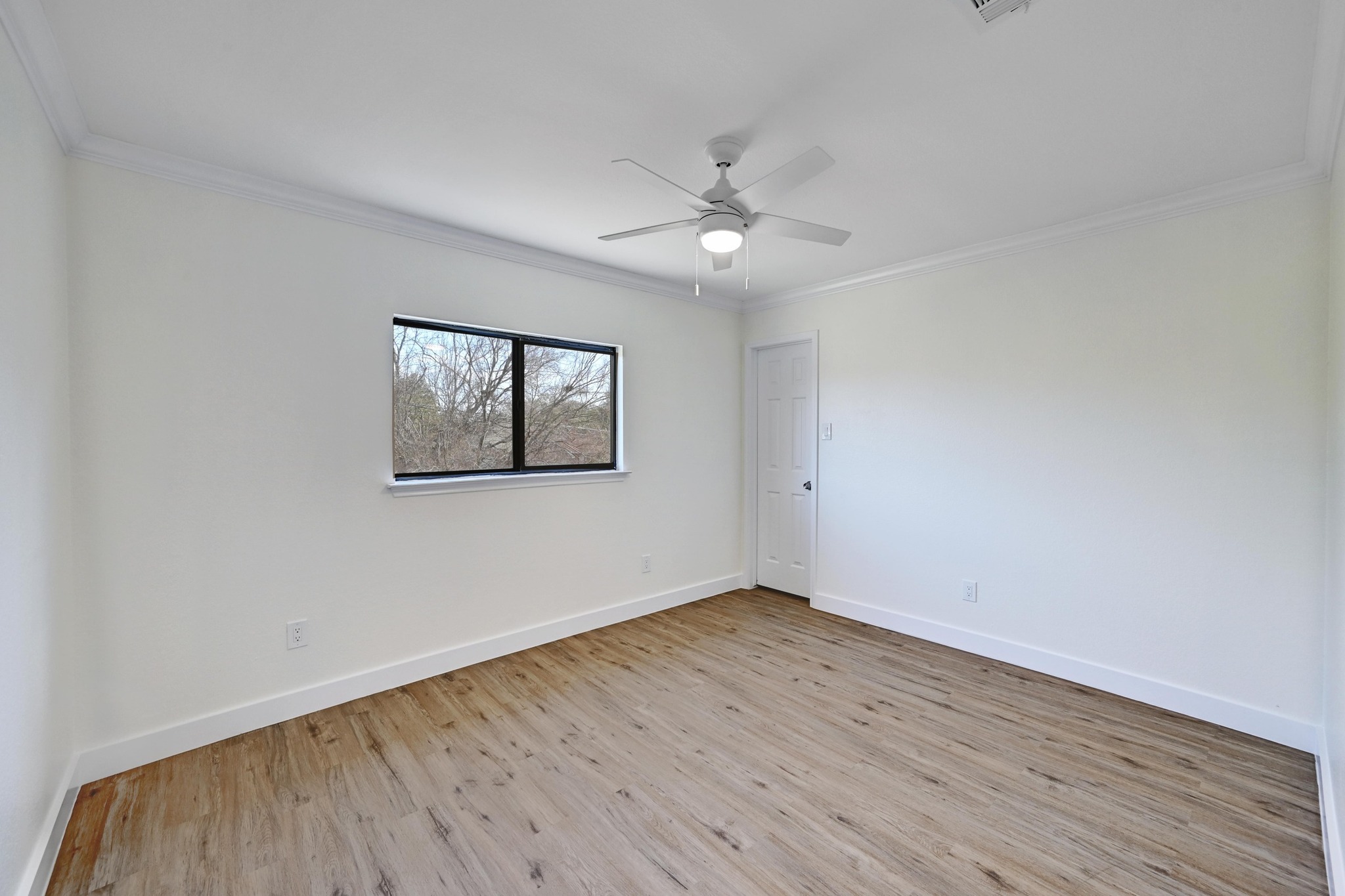 7413 L Marble Ridge Drive Austin, TX 78747 - Photo 22 of 30 Spacious room featuring wood-finish flooring, white walls, and a ceiling fan with integrated lighting