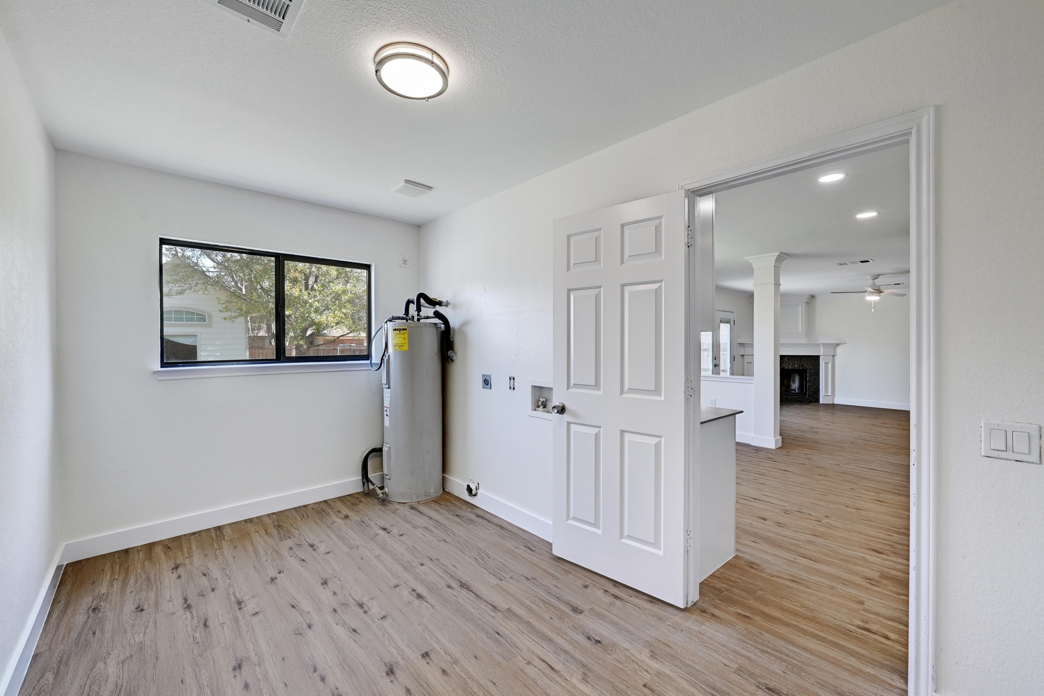 7413 L Marble Ridge Drive Austin, TX 78747 - Photo 23 of 30 Utility room featuring wood-finish flooring, white baseboards, and a single window with dark framing