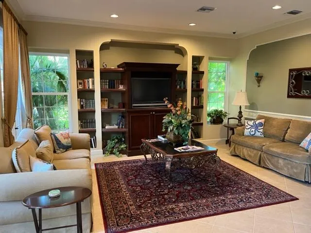 a living room with furniture potted plant and a large window
