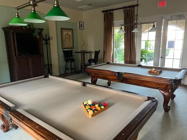 a living room with a table chairs and a refrigerator