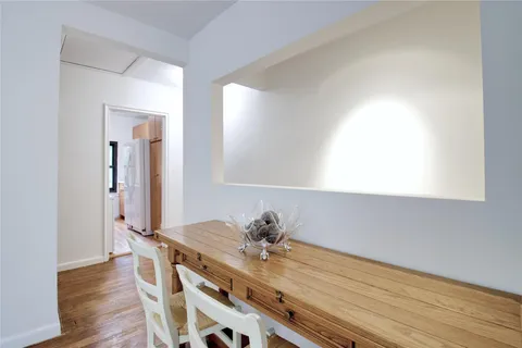 a view of a workspace room with wooden floor table and closet