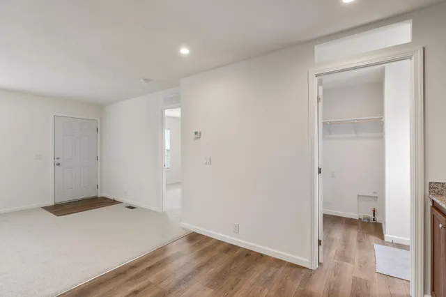 an empty room with wooden floor & closet and bathroom