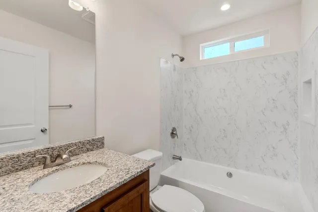 a bathroom with a granite countertop sink toilet and shower