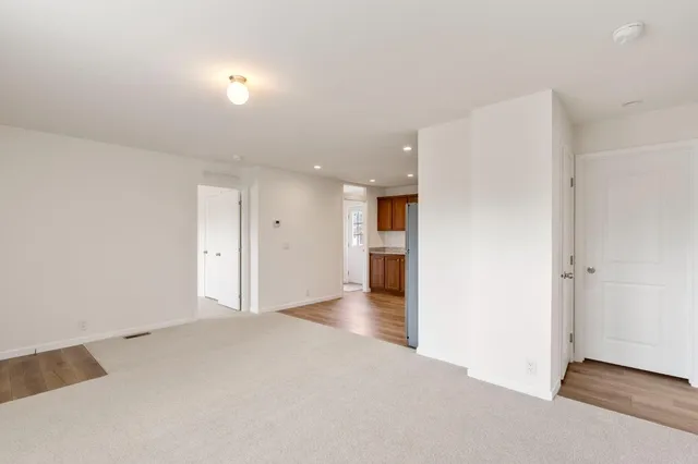 wooden floor in an empty room with a kitchen