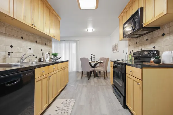 a kitchen with stainless steel appliances granite countertop sink stove top oven and cabinets