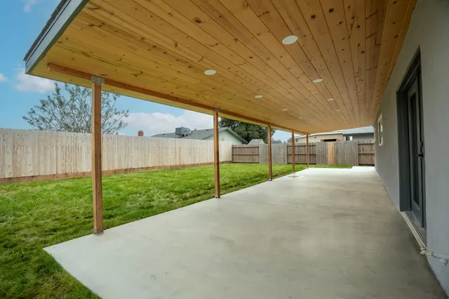 a view of a small yard in front of a house with a small yard and large tree