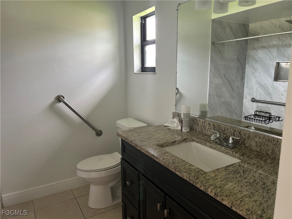 729 Southwest 46th Street Cape Coral, FL 33914 - Photo 12 of 20 a bathroom with a granite countertop sink a toilet and mirror