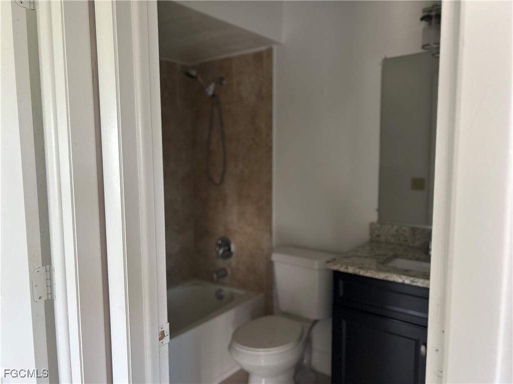 729 Southwest 46th Street Cape Coral, FL 33914 - Photo 15 of 20 a bathroom with a granite countertop toilet a sink and shower