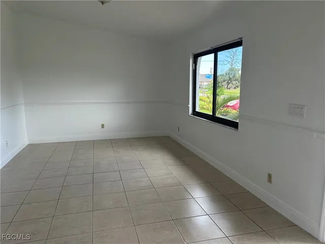 a view of a hallway with wooden floor and a living room
